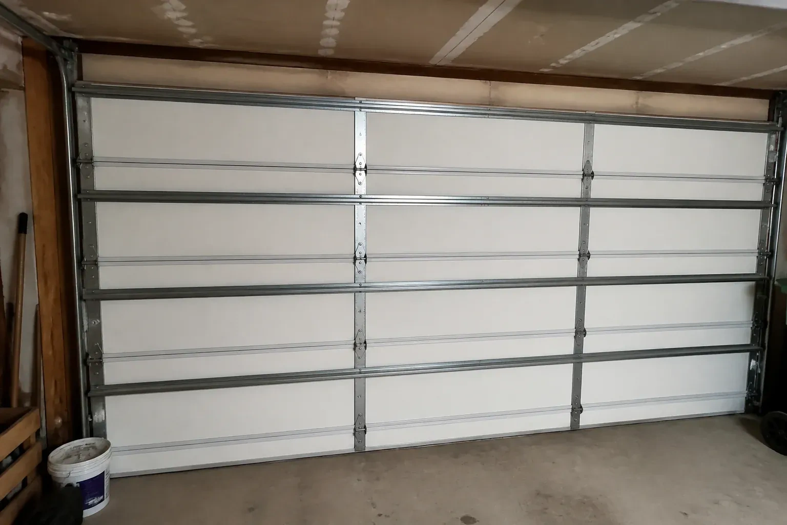 Interior of a closed sectional door with horizontal metal reinforcement struts. — Wind-Rated Garage Door Replacement, Scugog